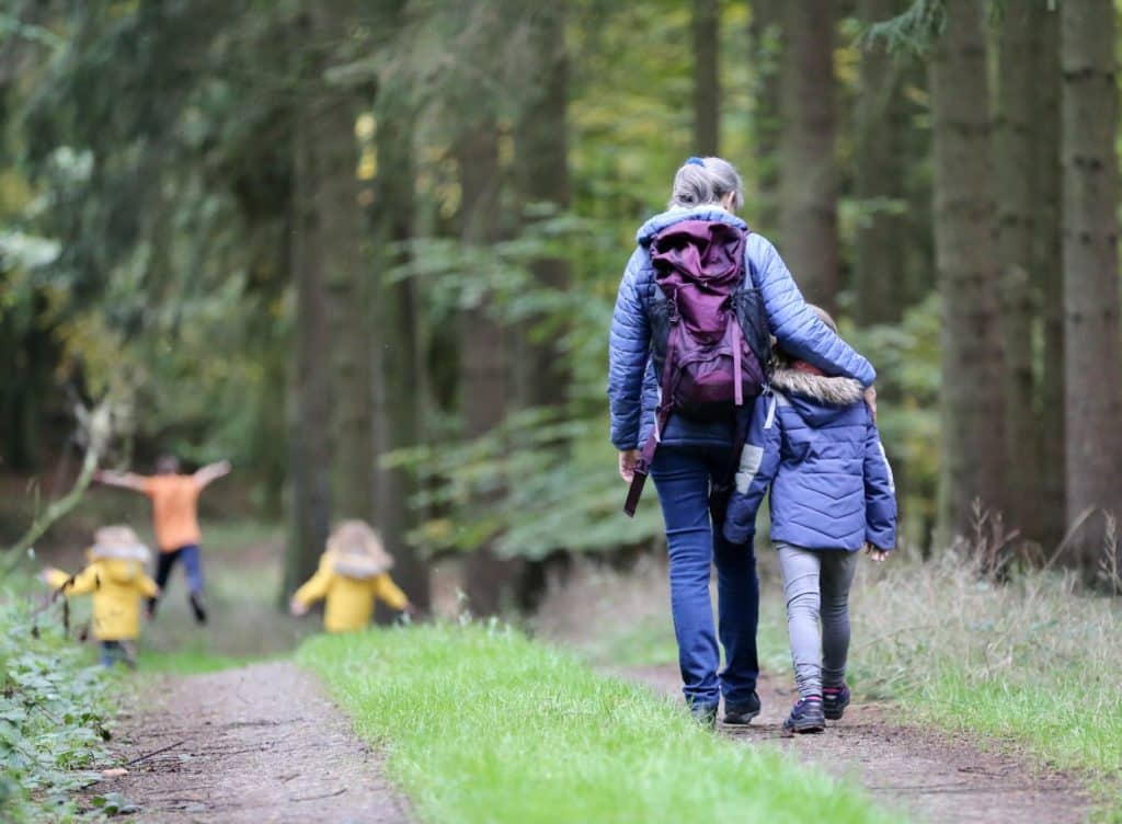 Femme et famille marchant dans la forêt