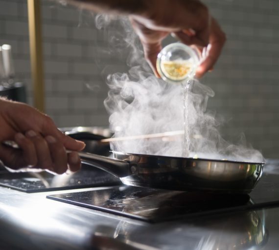 Une personne cuisine sur une cuisinière électrique à l’aide d’une poêle à frire