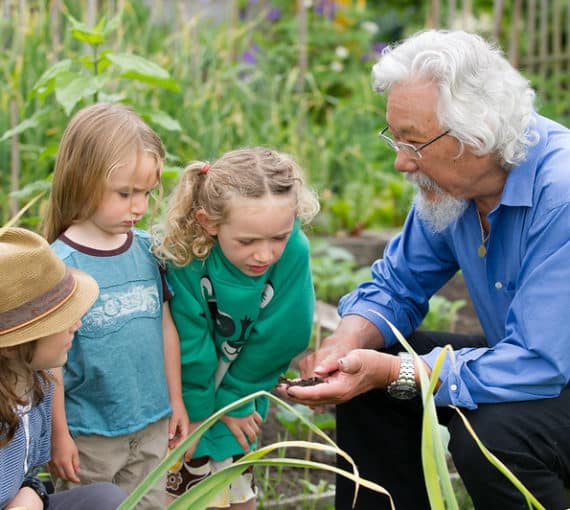Des enfants et David Suzuki se rassemblent dans un jardin