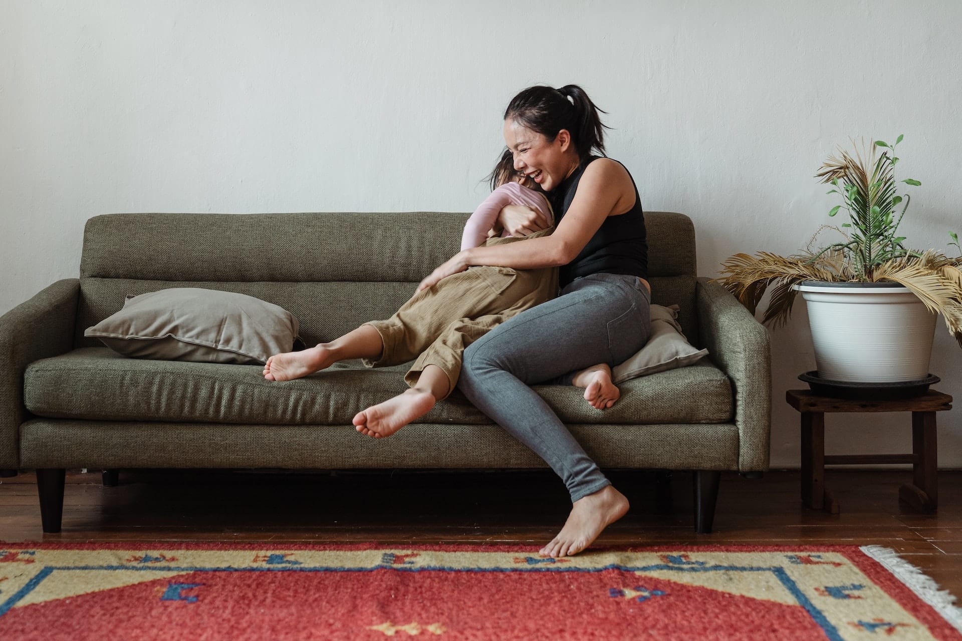 Femme donne un câlin à son enfant sur le sofa