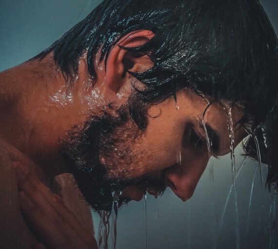 Homme qui lave ses cheveux dans la douche