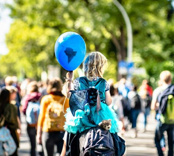 Enfant tenant un ballon bleu représentant la Terre.