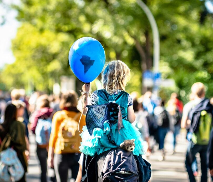 Enfant tenant un ballon bleu représentant la Terre.